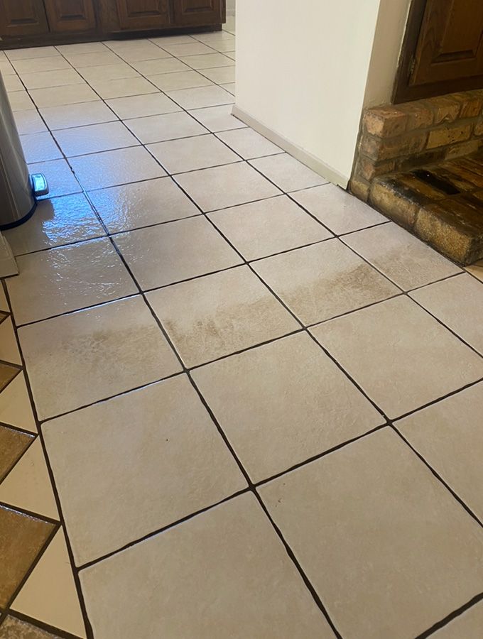 Dirty, tiled kitchen floor with visible stains and dark grout.