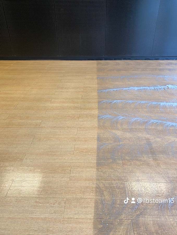 Half-cleaned wooden surface, light wood on the left, darker and dirty on the right, beneath a dark screen.