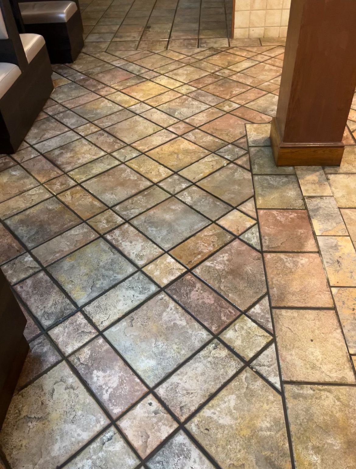 Tiled floor in a restaurant with a diagonal pattern in shades of beige, brown, and red.
