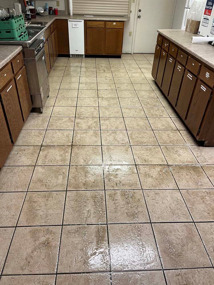 Kitchen with tan tile floor and wooden cabinets; a dishwasher is visible.