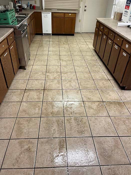 Kitchen with brown tile floor, wooden cabinets, stainless steel appliances, and white appliances.