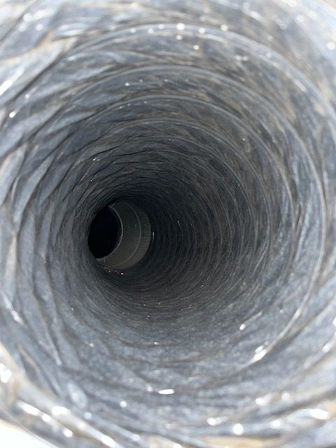 Looking down a dark, spiral-shaped flexible duct. Silver and gray interior, black center.