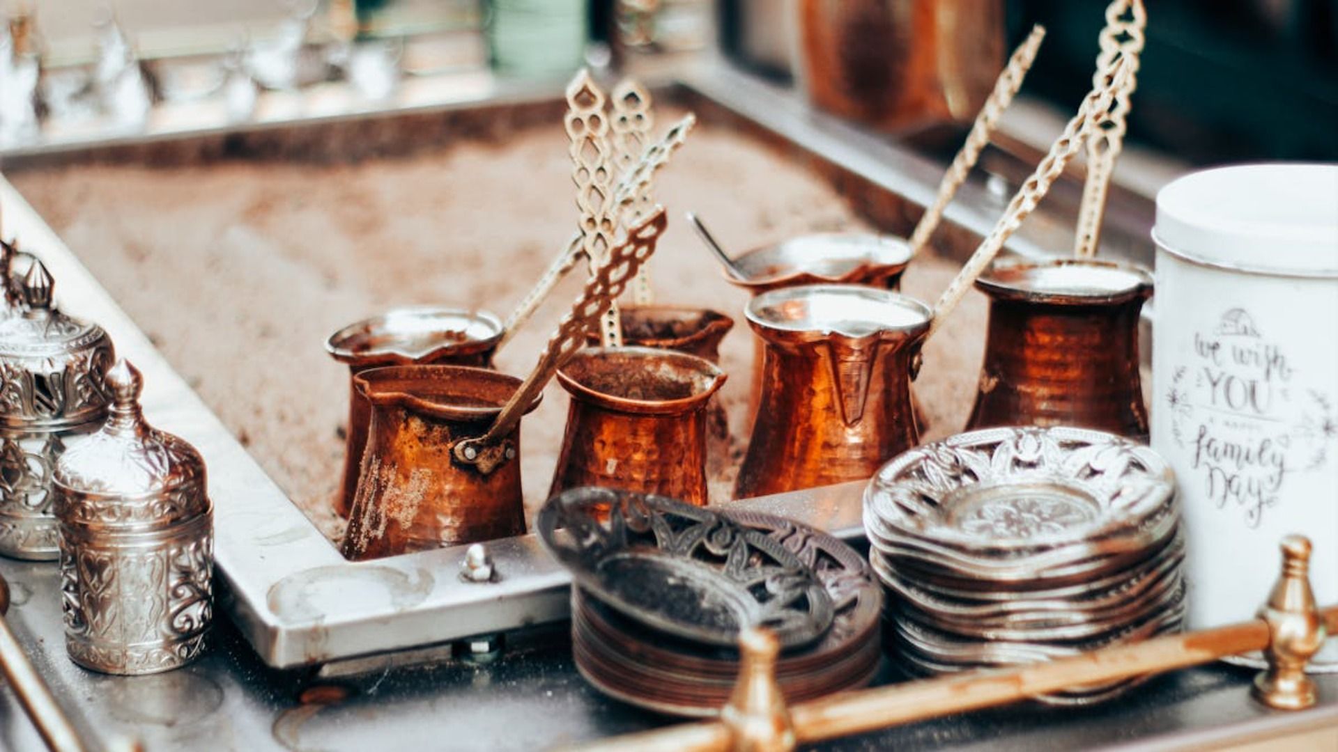 Cafeteras de cobre en arena, preparadas para elaborar café turco.