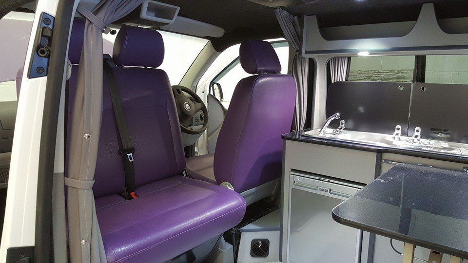 customers van with upholstered seats, sink, fridge, cooker and table