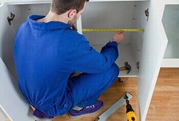 Repair Man Measuring Something — Custom Cabinets in Griffith, IN