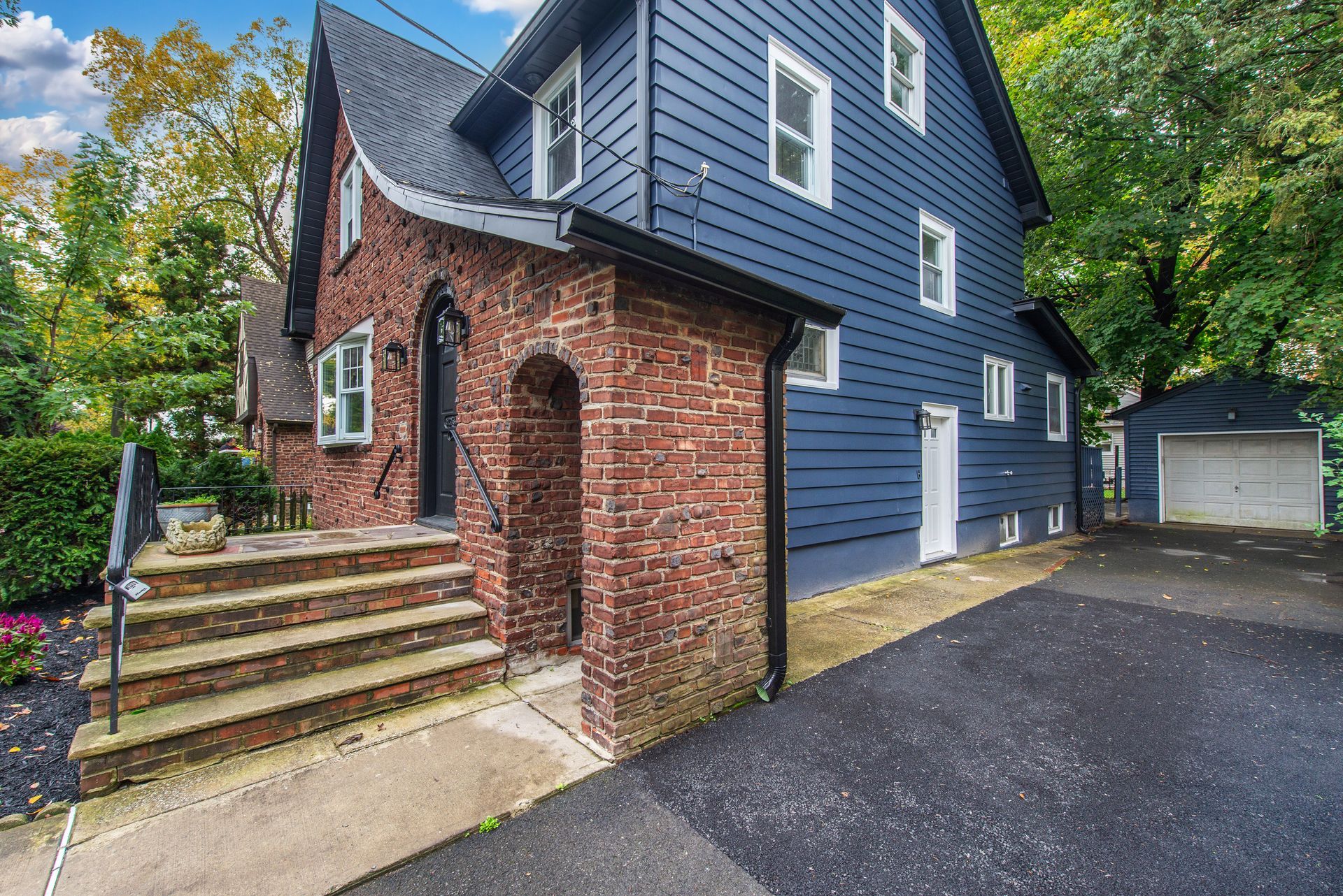 A blue house with a brick wall and a garage