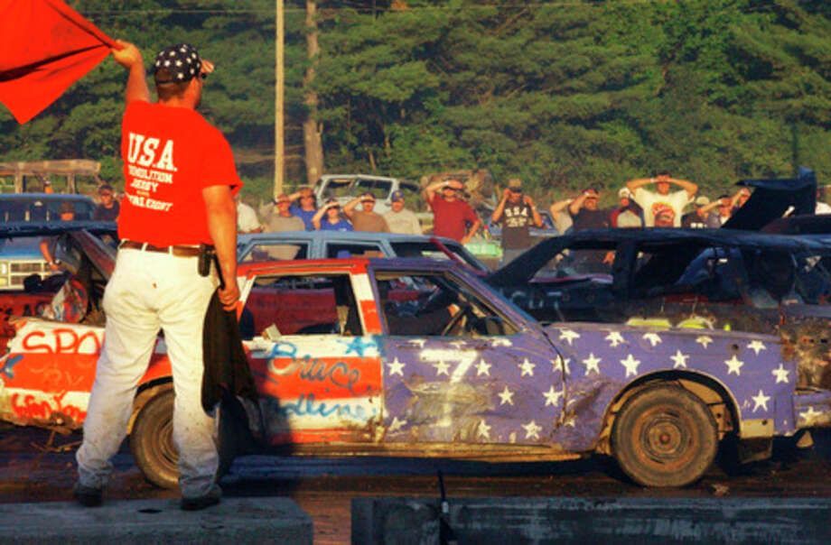 A man in a red usa shirt holds a red flag