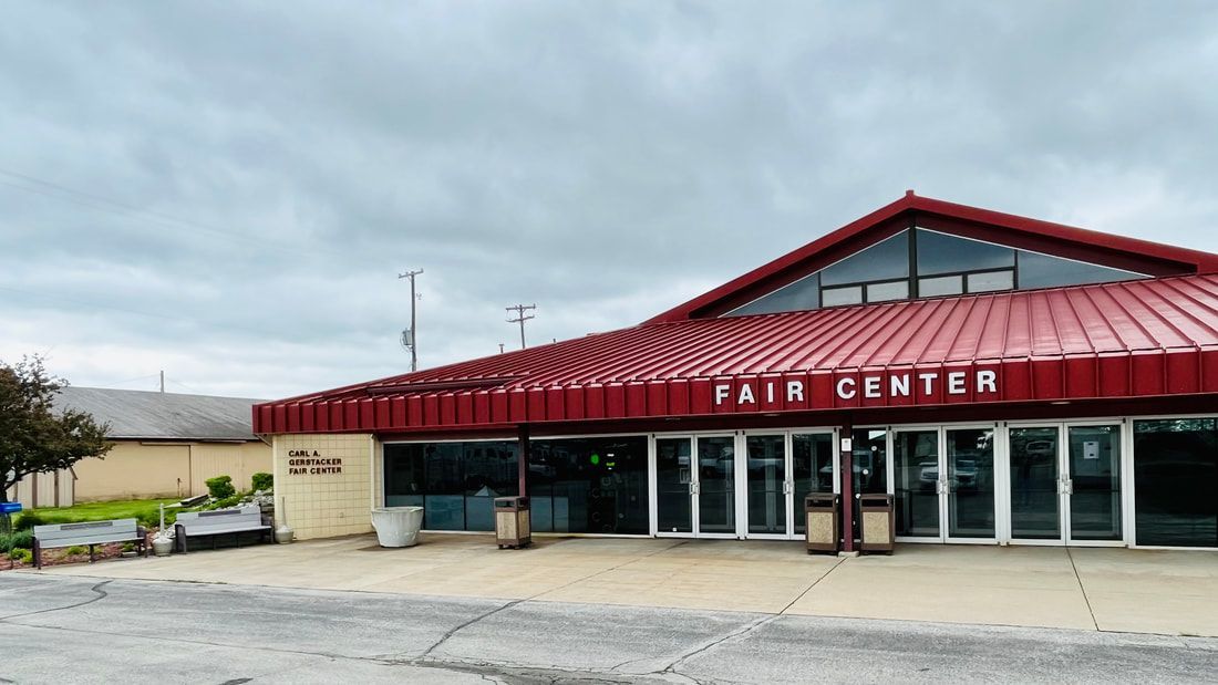 The fair center is a large building with a red roof.