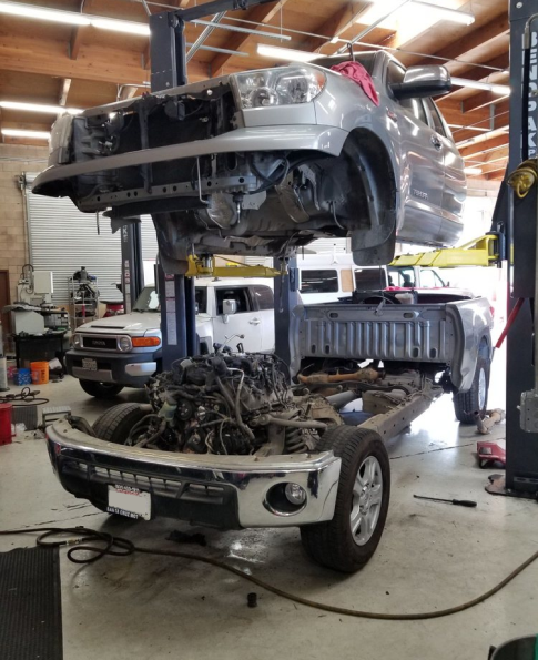A truck is being worked on by a mechanic in a garage | AE Motorsports