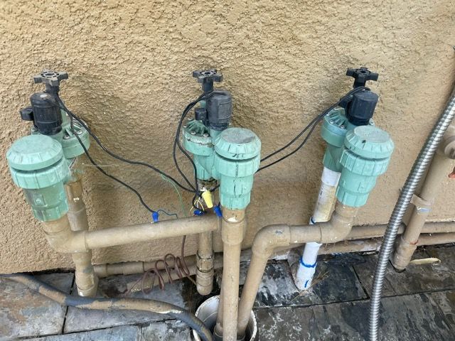 A bunch of pipes and valves are connected to a wall.