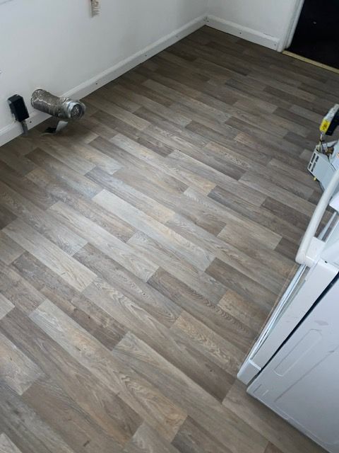 A kitchen with a wooden floor and a white stove.