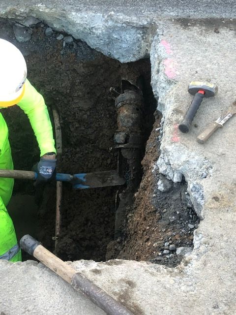 A man is digging a hole in the ground with a shovel