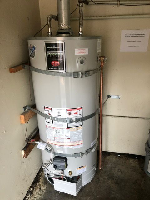 A large water heater is sitting in a room next to a wall.