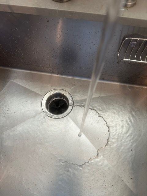A close up of a sink with water coming out of it