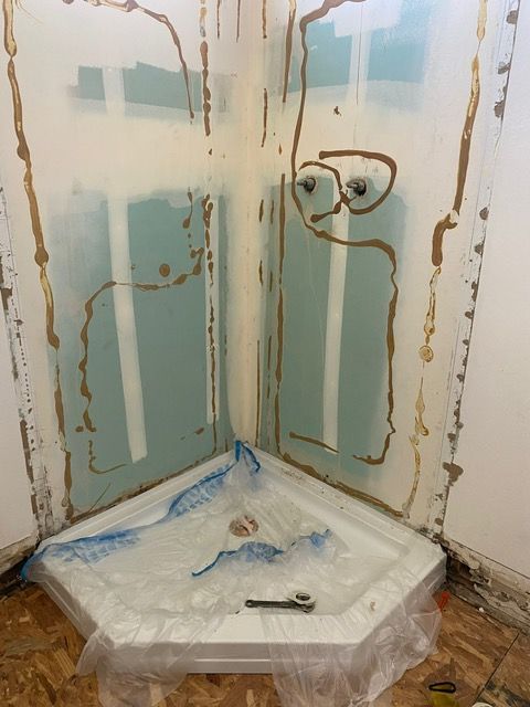 A shower stall is being built in a bathroom.