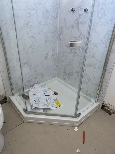 A bathroom with a shower stall and a toilet.