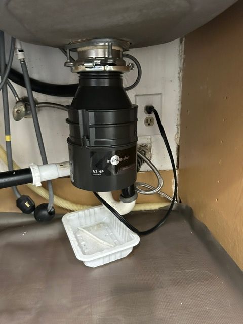 A garbage disposal is under a sink in a kitchen