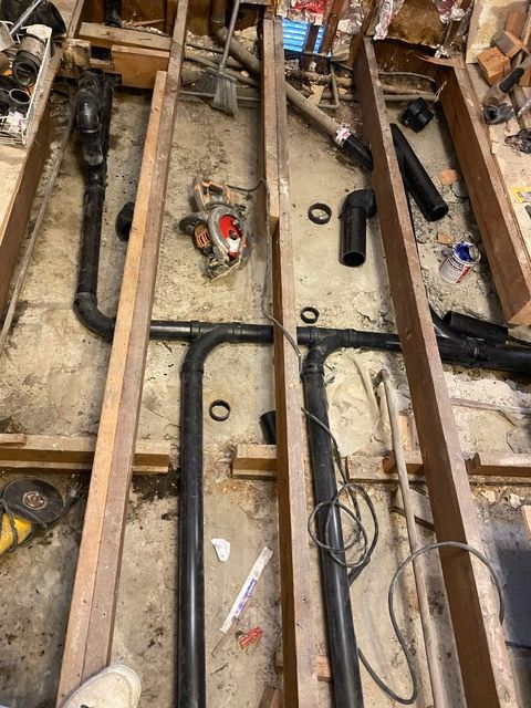 A bunch of pipes are laying on the floor in a room.