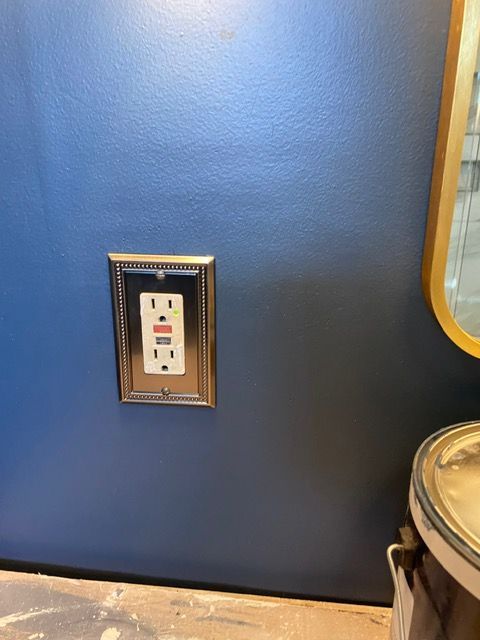 A blue wall with a white electrical outlet on it