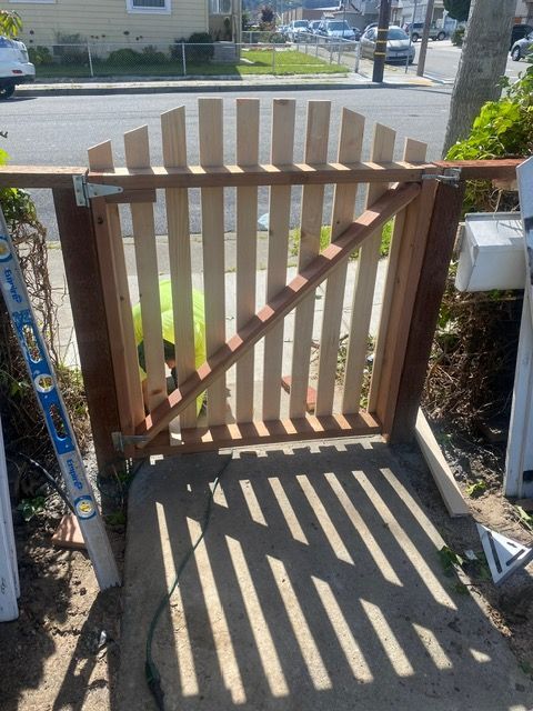 A wooden gate is being built next to a ladder.