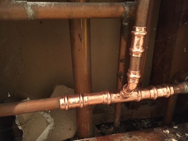 A close up of a copper pipe in a room.