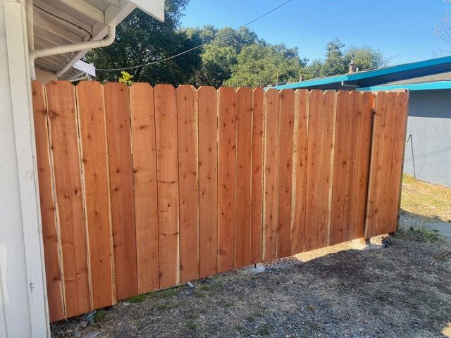 A wooden fence is sitting next to a house.