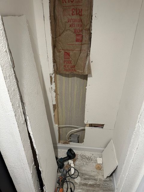 A room with a hole in the wall and a box on the wall.