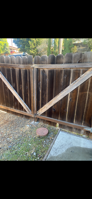 A wooden fence with a gate built into it.