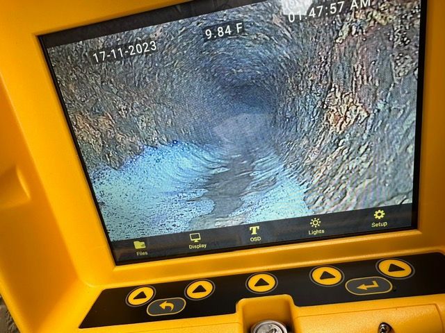 A yellow device shows a picture of a drain and the time is 9:47 am