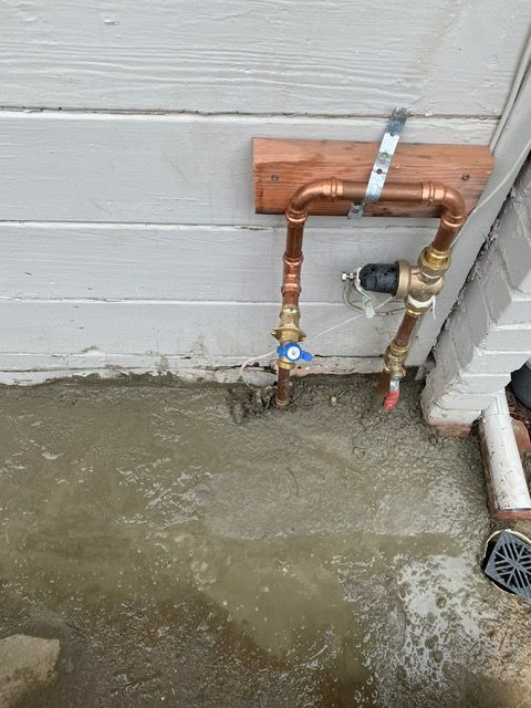 A copper pipe is attached to the side of a building.