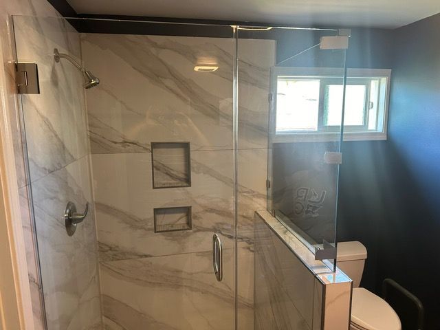 A bathroom with a walk in shower and a toilet.