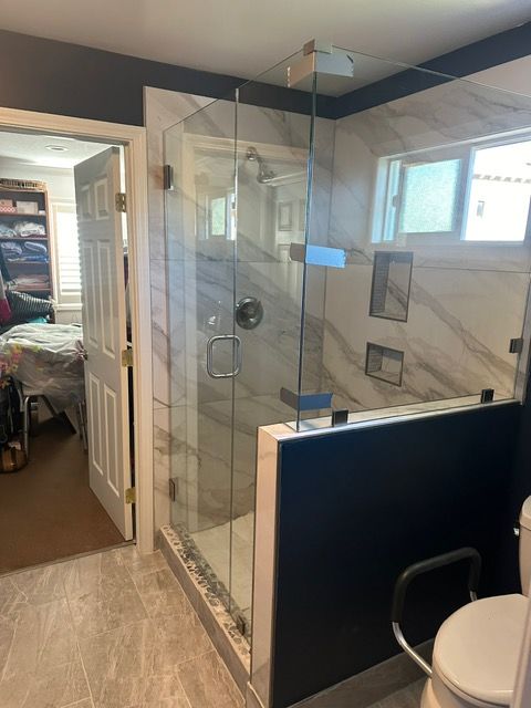 A bathroom with a walk in shower and a toilet