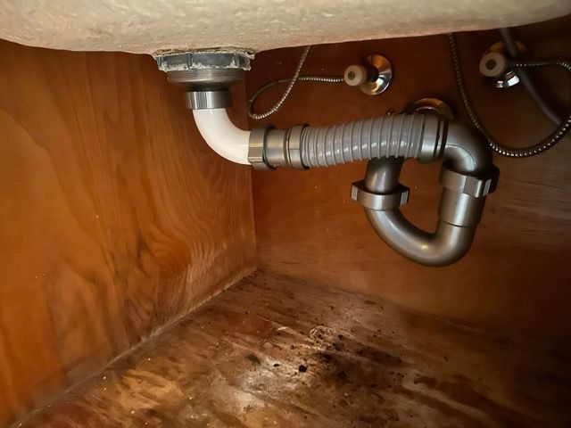 A sink with a drain pipe underneath it