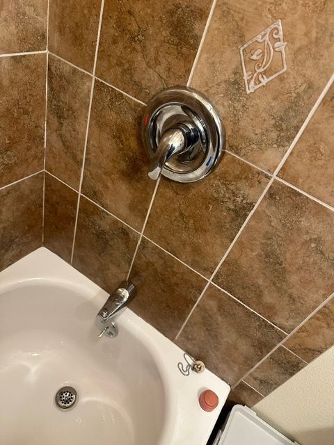 A bathroom with a bathtub and a shower faucet