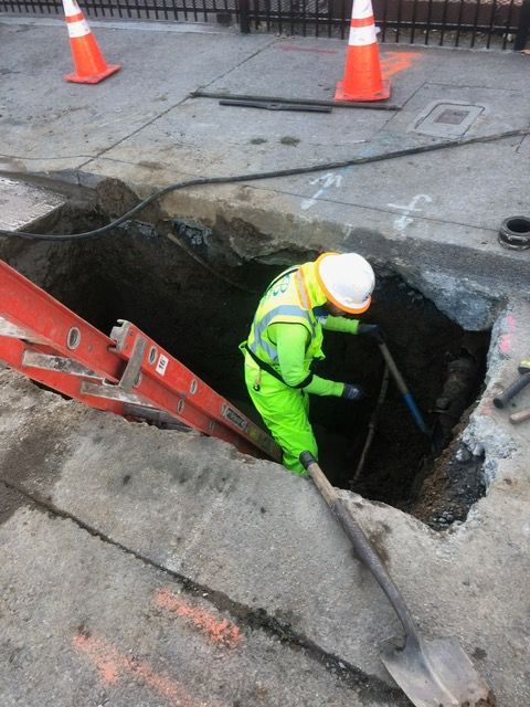 A man is digging a hole in the ground with a shovel