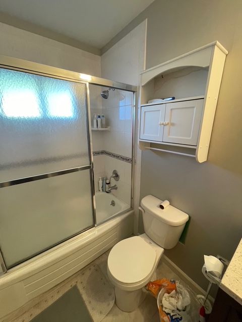 A bathroom with a toilet , tub and shower.