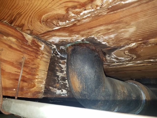 A pipe is hanging from the ceiling of a wooden building.