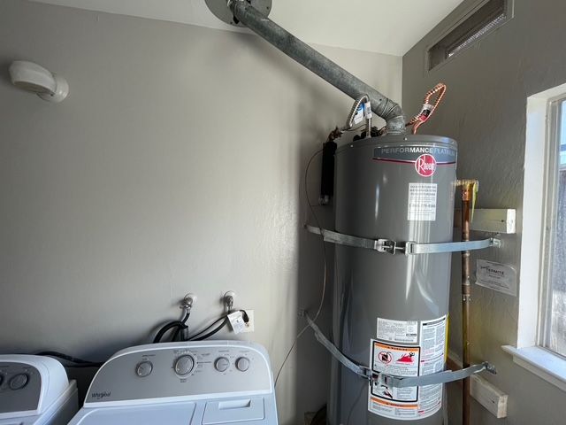 A laundry room with a washer and dryer and a water heater