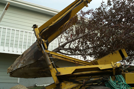 A yellow tractor is parked in front of a house