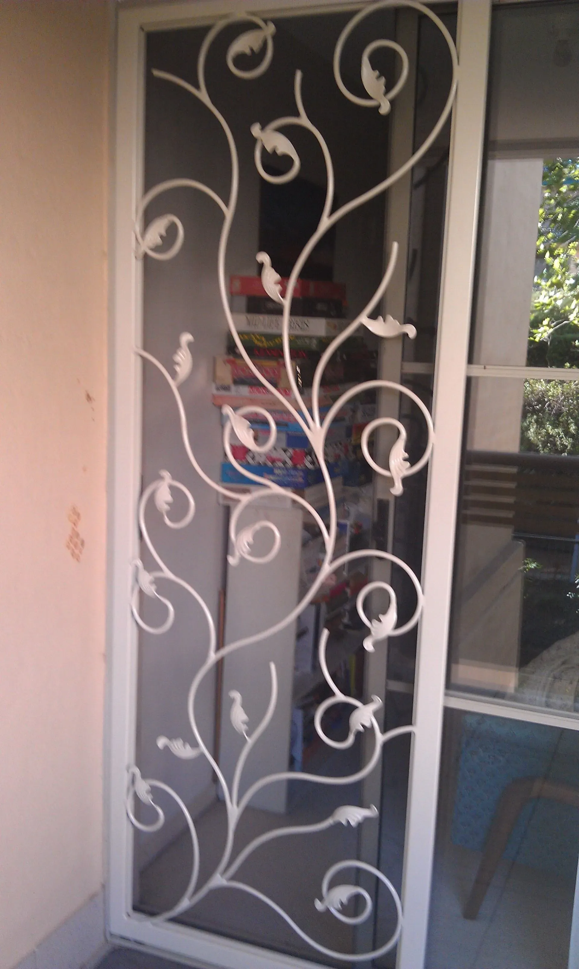 A sliding glass door with a wrought iron design on it
