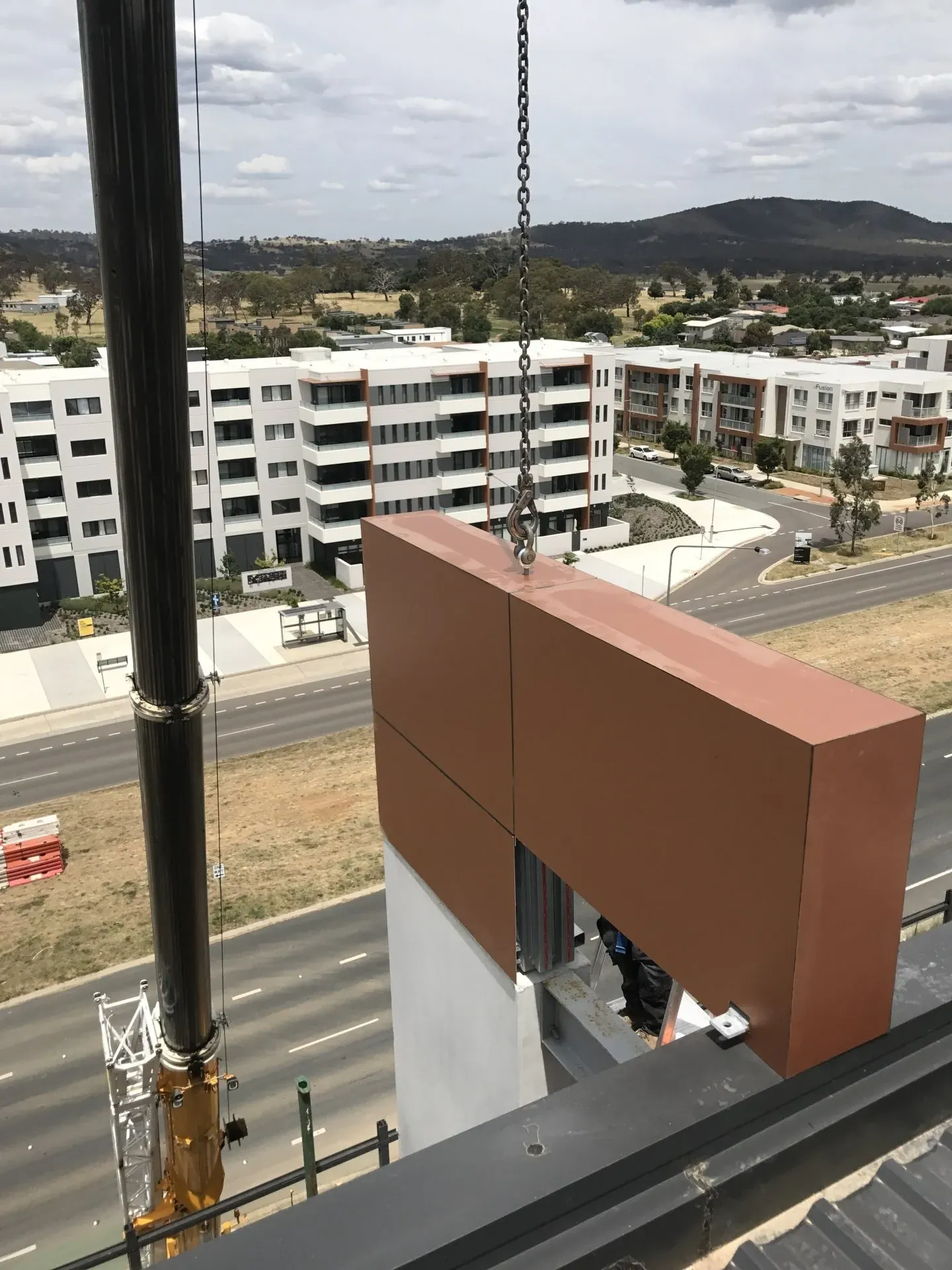 A large piece of wood is being lifted by a crane.