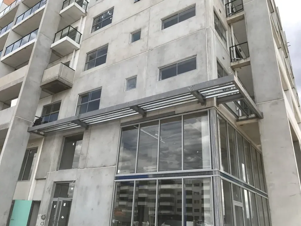 A large building with a lot of windows and balconies is under construction.