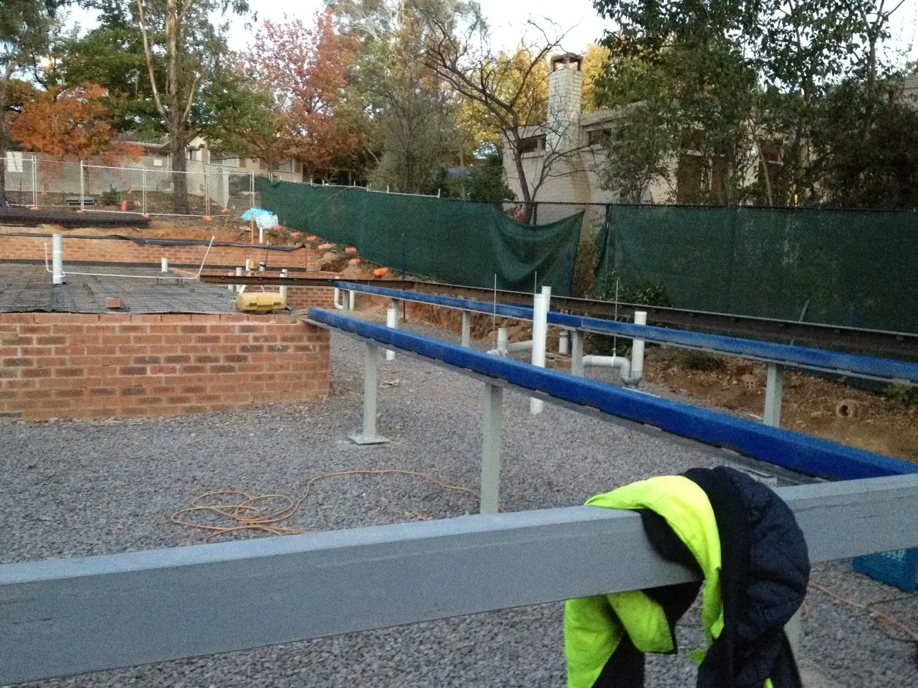A person in a yellow vest is leaning on a railing