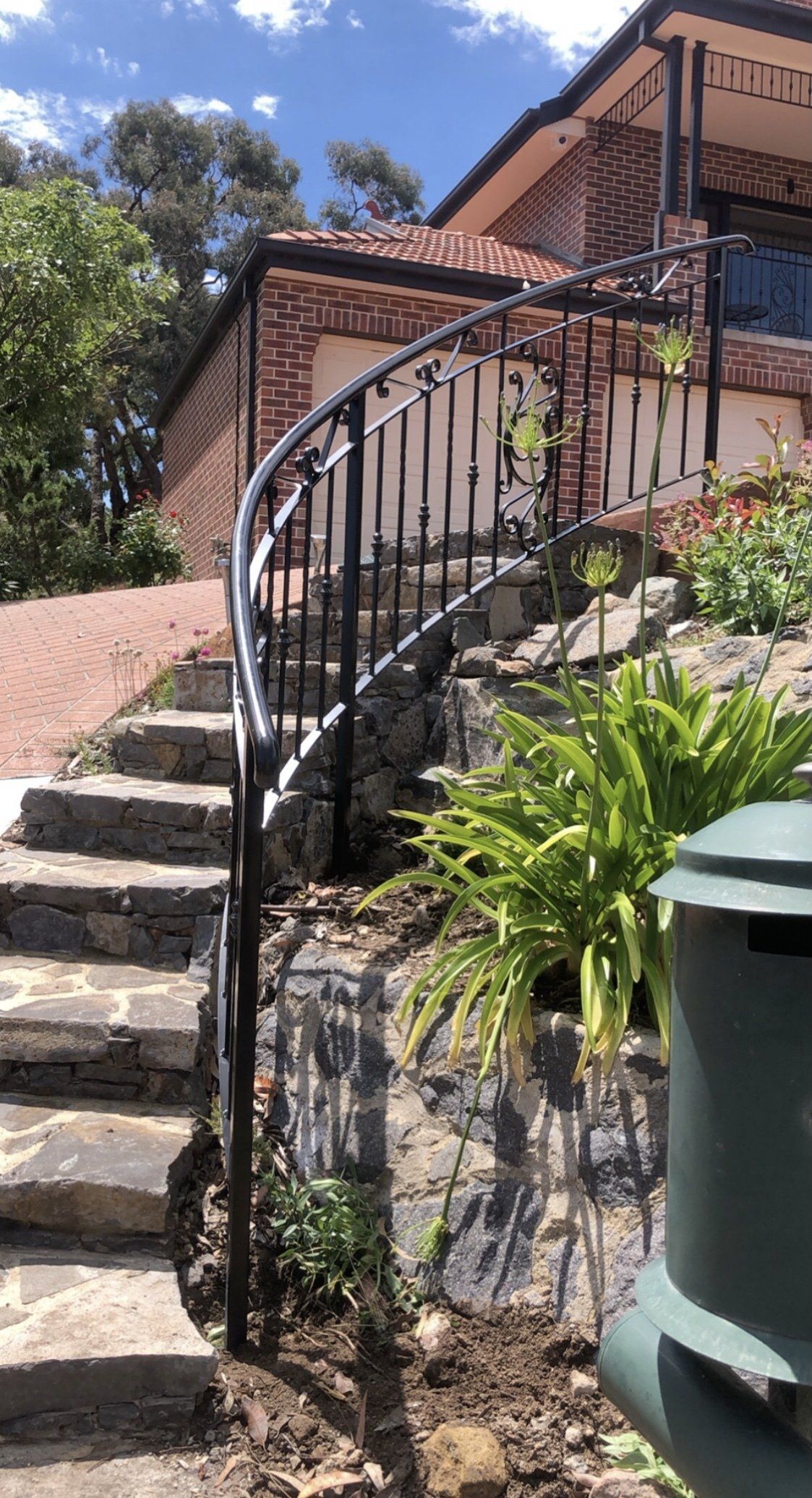 A set of stairs leading up to a house with a wrought iron railing.