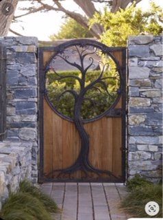 A wooden gate with a metal tree design on it