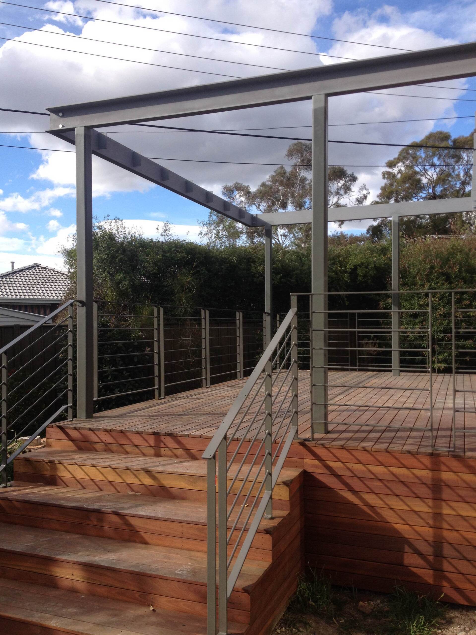 A wooden deck with stairs and a metal railing