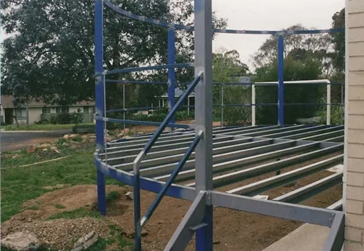 A blue metal structure with stairs leading up to it