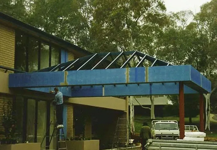 A man standing on a ladder in front of a building