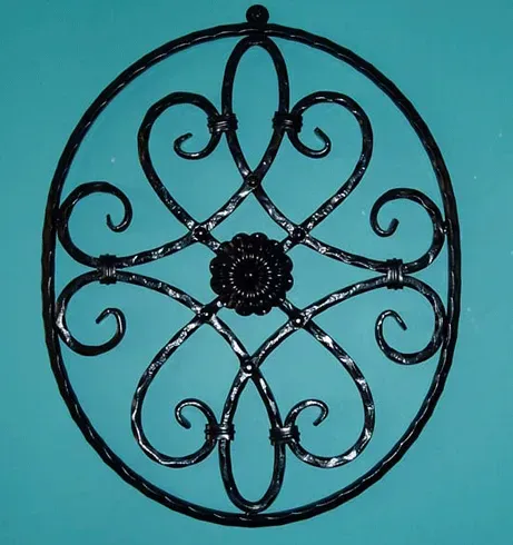 A wrought iron circle with swirls and a flower in the center