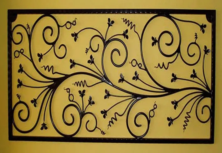 A wrought iron design with swirls and flowers on a yellow background